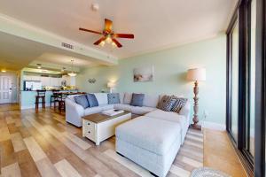 a living room with a couch and a ceiling fan at Beachfront condo with pool private balcony and laundry in Dauphin Island
