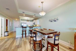 a kitchen and dining room with a table and chairs at Beachfront condo with pool private balcony and laundry in Dauphin Island