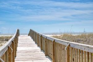 a wooden boardwalk leading to the beach at Holiday Isle 618 in Dauphin Island