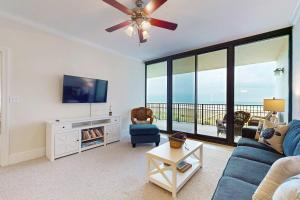 a living room with a blue couch and a ceiling fan at Holiday Isle 618 in Dauphin Island