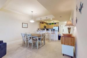 a kitchen and dining room with a table and chairs at Holiday Isle 618 in Dauphin Island +26 photos