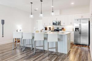 a kitchen with white cabinets and a stainless steel refrigerator at The Anchor Holds in Dauphin Island