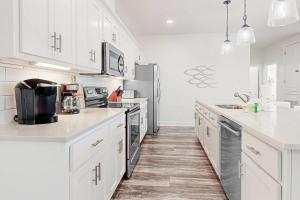 a kitchen with white cabinets and stainless steel appliances at The Anchor Holds in Dauphin Island