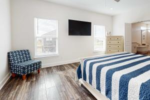 a bedroom with a bed and a chair and a television at The Anchor Holds in Dauphin Island +8 photos
