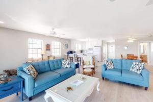 a living room with two blue couches and a table at Little Grand Hotel in Dauphin Island