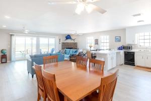 a kitchen and living room with a wooden table and chairs at Little Grand Hotel in Dauphin Island