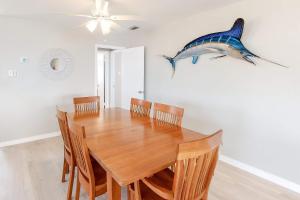 a dining room with a wooden table and a shark on the wall at Little Grand Hotel in Dauphin Island