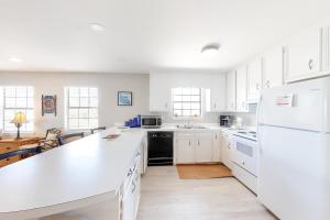 a kitchen with white cabinets and a white counter top at Little Grand Hotel in Dauphin Island +19 photos