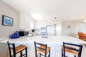 a kitchen with a large white island with two chairs at Little Grand Hotel in Dauphin Island