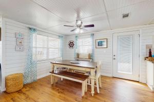 a dining room with a table and a ceiling fan at Macs Fish Camp in Dauphin Island