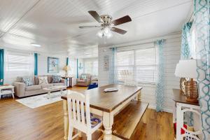 a living room with a table and a ceiling fan at Macs Fish Camp in Dauphin Island