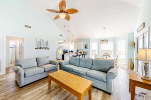 a living room with two blue couches and a table at Sunset Beach in Dauphin Island