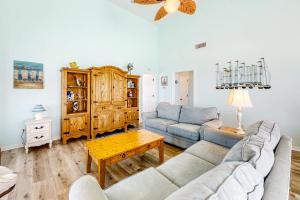 a living room with two couches and a table at Sunset Beach in Dauphin Island