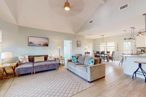 a living room with two couches and a kitchen at Bale Oasis in Dauphin Island