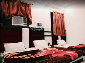 a bedroom with two beds and a air conditioner at Hotel Marwari in Agra +30 photos