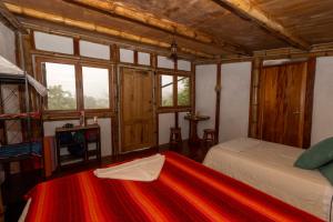 a bedroom with a bed and a tv and windows at Highland Bamboo Cabin, San Cristóbal Galápagos in San Cristóbal