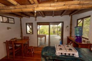 a kitchen with a stove and a dining room with a table at Highland Bamboo Cabin, San Cristóbal Galápagos in San Cristóbal