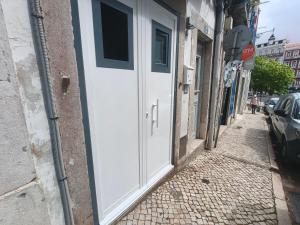 a white door on the side of a building at Estúdio Madragoa in Lisbon