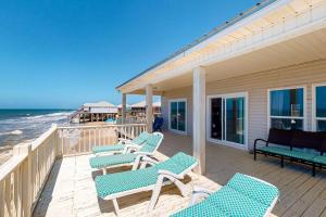 a porch with blue chairs and the ocean at Sea the Gulf in Dauphin Island