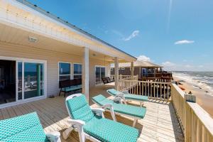a deck with blue chairs and the beach at Sea the Gulf in Dauphin Island +20 photos