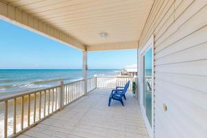 a porch with a blue chair on the beach at Sea the Gulf in Dauphin Island