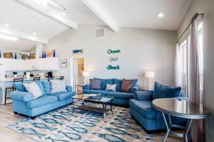 a living room with blue couches and a table at Sea the Gulf in Dauphin Island