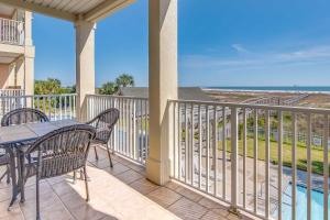a patio with a table and chairs on a balcony at Gulf-front condo with lock-out feature shared pools & amazing views in Dauphin Island