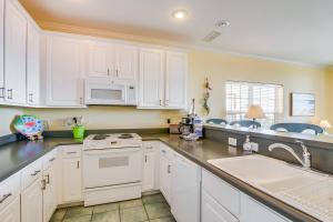 a kitchen with white cabinets and a sink at Gulf-front condo with lock-out feature shared pools & amazing views in Dauphin Island