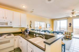 a kitchen with white cabinets and a counter top at Gulf-front condo with lock-out feature shared pools & amazing views in Dauphin Island +36 photos