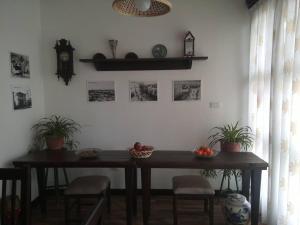 a table in a room with plants and a clock at Hotel Bujtina e Bardhe in Korçë