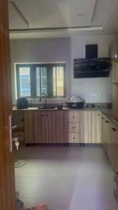 a kitchen with wooden cabinets and a sink and two windows at Yaba Elite Stays in Lagos