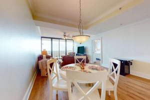 a dining room and living room with a table and chairs at Holiday Isle 413 in Dauphin Island