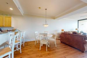 a living room with a couch and a table and chairs at Holiday Isle 413 in Dauphin Island