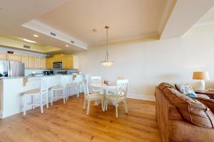 a living room with a couch and a table with chairs at Holiday Isle 413 in Dauphin Island