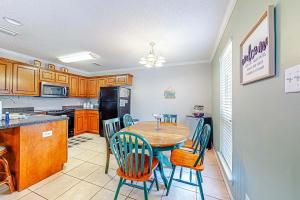 a kitchen with a table and chairs in a kitchen at Perfectly located condo with beach access - deck internet W&D & AC in Dauphin Island