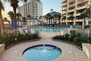 a swimming pool in a courtyard with a building at Spacious beachfront condo with full kitchen shared pool and beach access in Gulf Shores