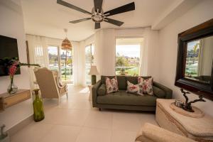 a living room with a couch and a ceiling fan at Caribbean Beachfront Resort in Puerto Plata