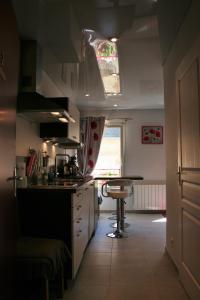 eine Küche mit einem Waschbecken und einem Tisch darin in der Unterkunft Les Hellebores in Caudebec-en-Caux