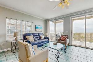 a living room with a couch and a table at Gulf-Front Condo with Balcony Shared Pools and Beach Access in Dauphin Island