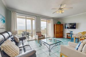 a living room with a couch and a table at Gulf-Front Condo with Balcony Shared Pools and Beach Access in Dauphin Island