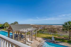 a balcony with a view of a swimming pool and the beach at Gulf-Front Condo with Balcony Shared Pools and Beach Access in Dauphin Island