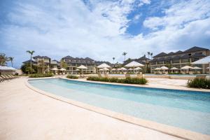 a swimming pool at a resort with umbrellas at Caribbean Beachfront Resort in Puerto Plata