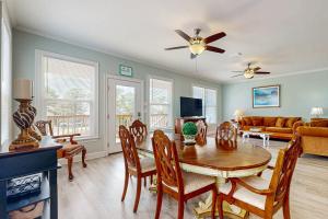 a living room with a table and chairs and a couch at Gulfview duplex with panoramic views large balcony and internet in Dauphin Island
