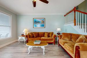 a living room with a couch and a table at Gulfview duplex with panoramic views large balcony and internet in Dauphin Island