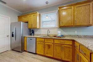 a kitchen with wooden cabinets and a stainless steel refrigerator at Gulfview duplex with panoramic views large balcony and internet in Dauphin Island +17 photos