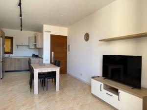 a kitchen and dining room with a table and a television at Fort Chambray Gozo 2BDR Apartment in Għajnsielem