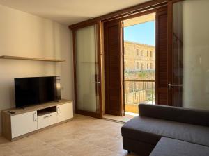 a living room with a flat screen tv and a couch at Fort Chambray Gozo 2BDR Apartment in Għajnsielem