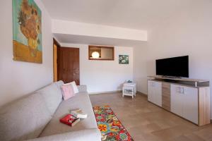 a living room with a couch and a flat screen tv at Sicilian Charm close to Taormina - Happy Rentals in Gaggi