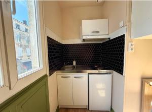 a small kitchen with a sink and a window at Appartement Martell in Cognac