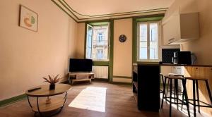 a living room with a table and a kitchen at Appartement Martell in Cognac